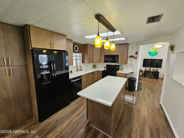 a kitchen with stainless steel appliances a stove a sink dishwasher and cabinets with wooden floor