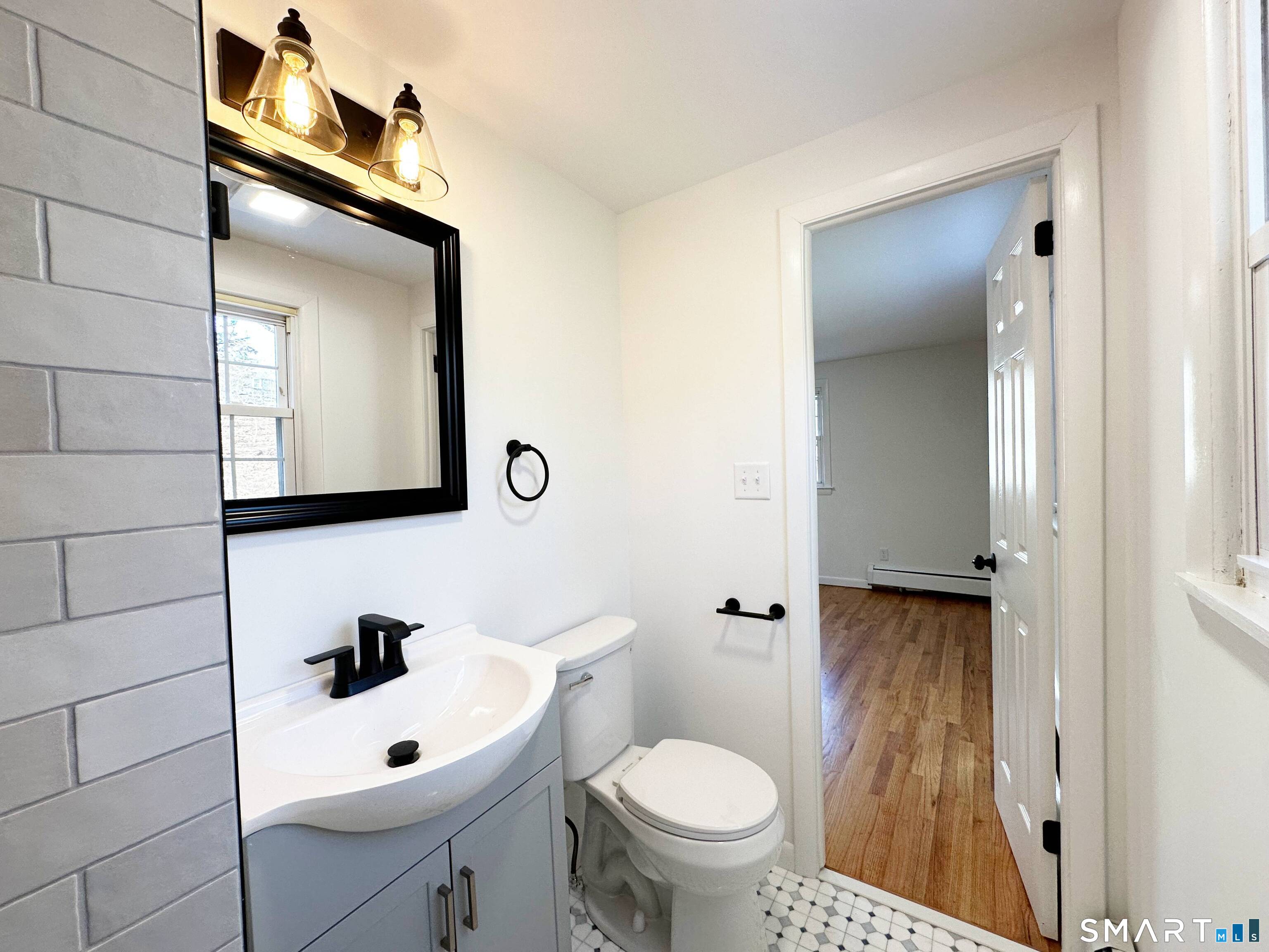 148 Hyde Road West Hartford, CT 06117 - Photo 18 of 24 a bathroom with a toilet sink and mirror
