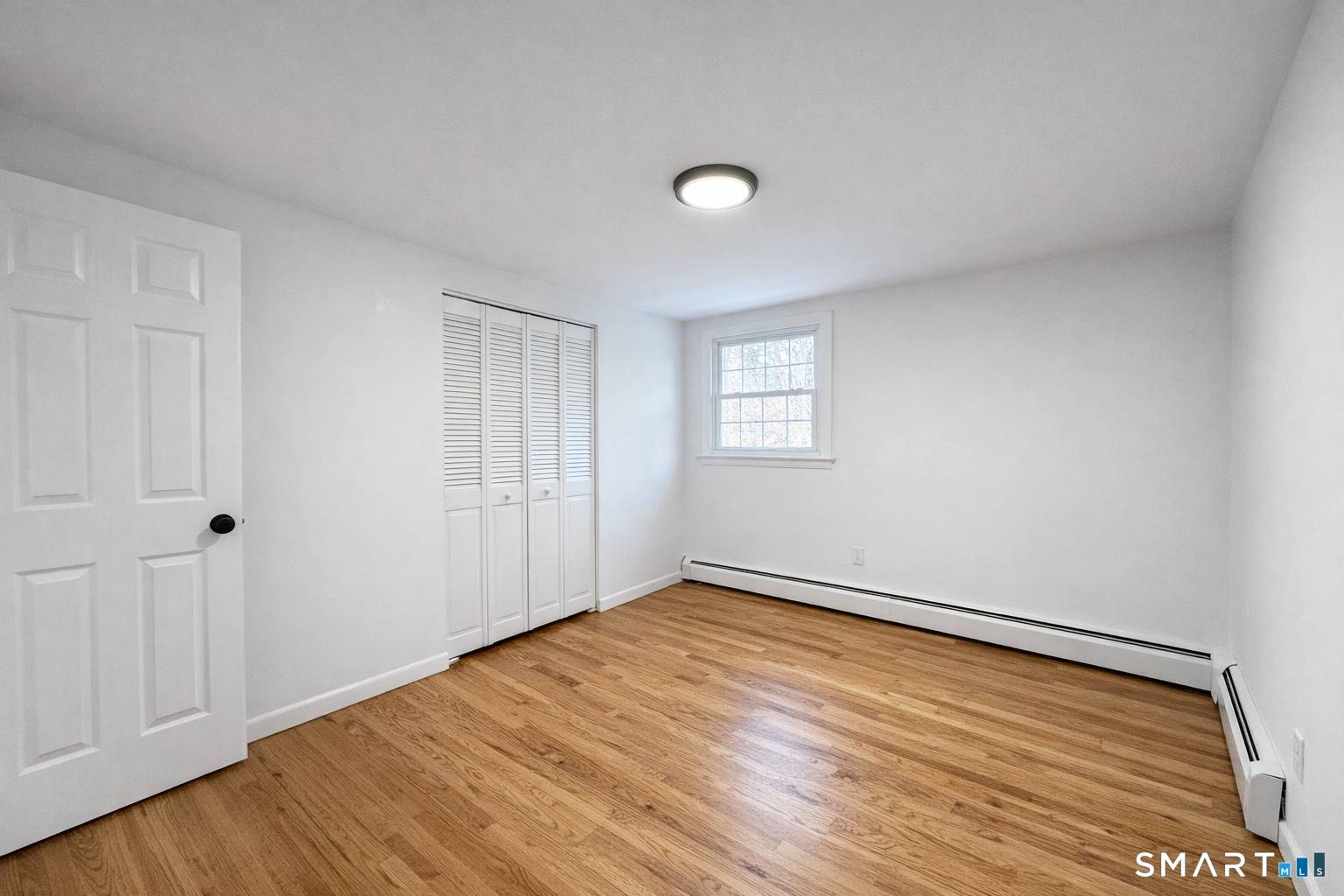 148 Hyde Road West Hartford, CT 06117 - Photo 20 of 24 a view of an empty room with wooden floor and a window