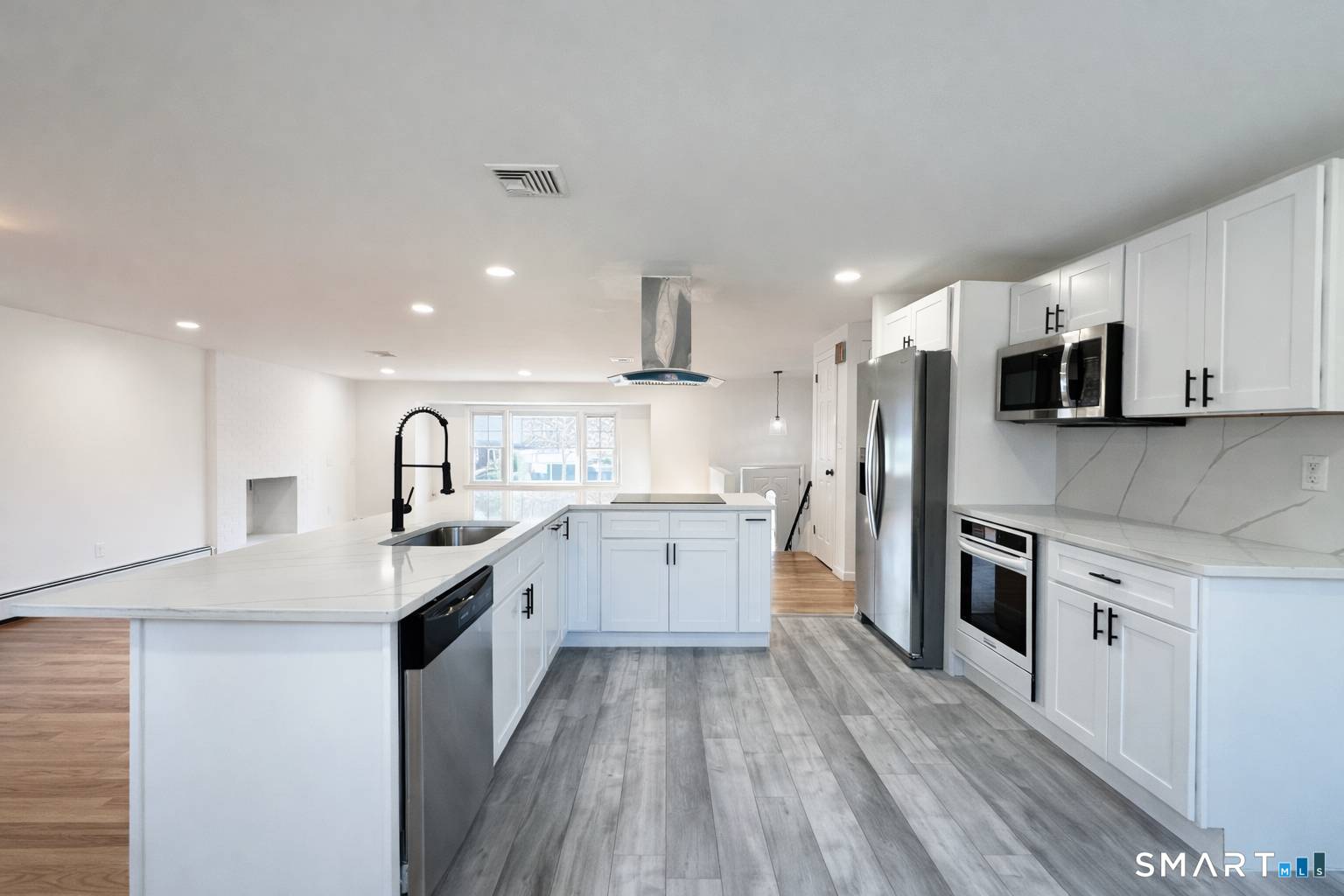 148 Hyde Road West Hartford, CT 06117 - Photo 7 of 24 a large kitchen with stainless steel appliances kitchen island a large counter top and a stove top oven
