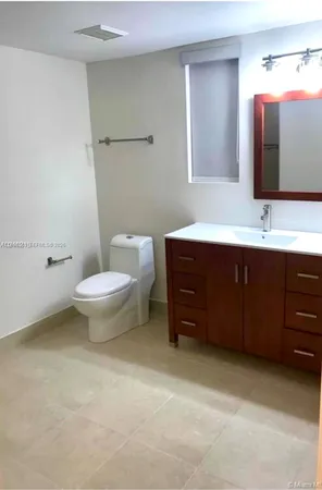 a bathroom with a sink mirror and toilet