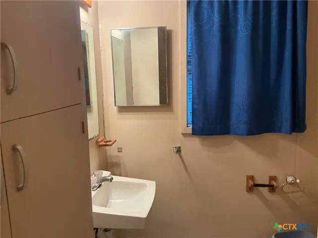 a bathroom with a sink a toilet and a mirror
