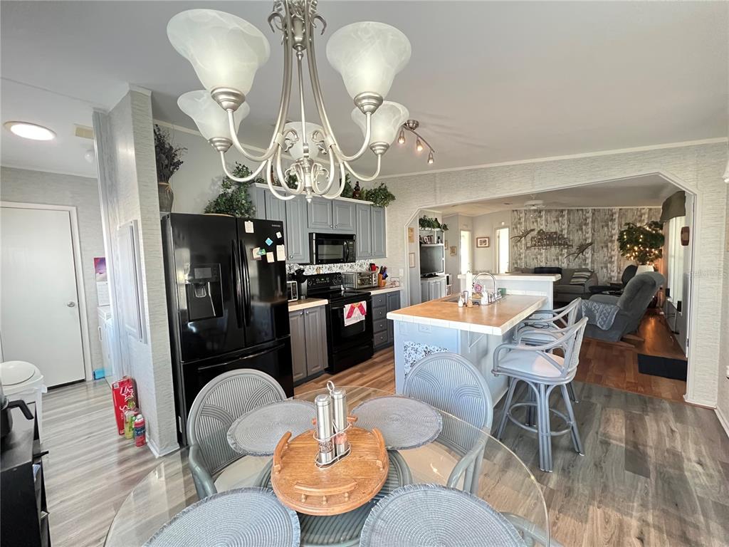 10100 Burnt Store Road, Unit 27 Punta Gorda, FL 33950 - Photo 12 of 37 a living room with furniture kitchen view and a chandelier
