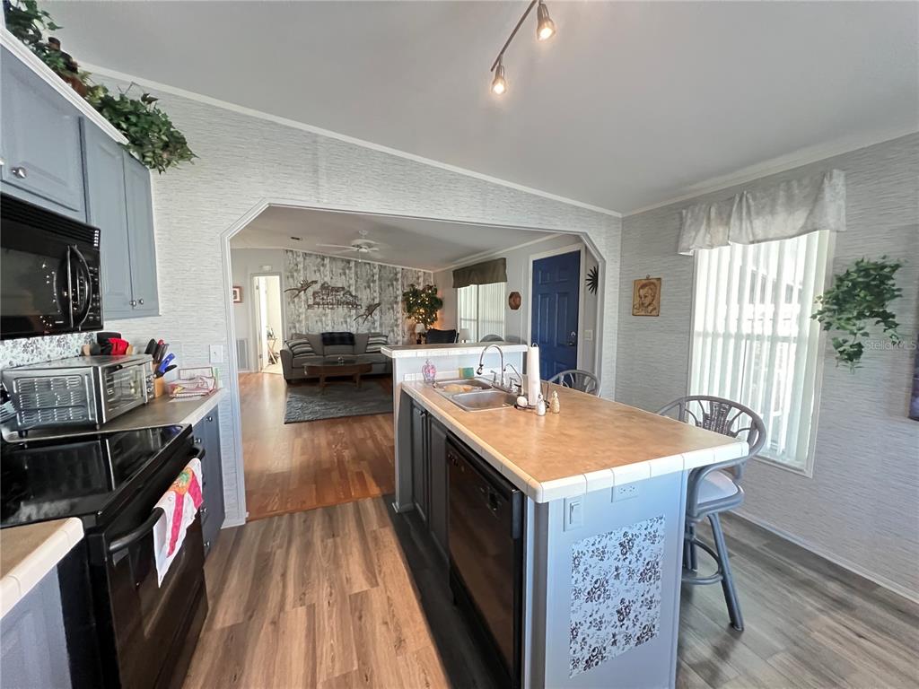 10100 Burnt Store Road, Unit 27 Punta Gorda, FL 33950 - Photo 13 of 37 a open kitchen with stainless steel appliances granite countertop a sink stove and refrigerator
