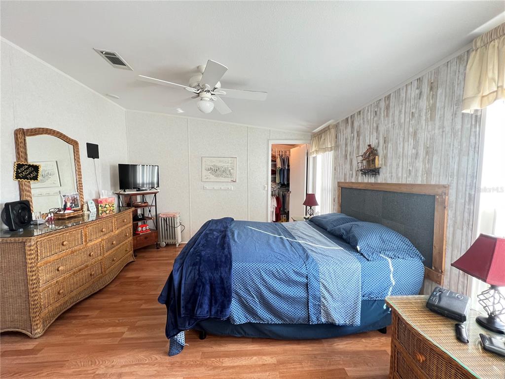 10100 Burnt Store Road, Unit 27 Punta Gorda, FL 33950 - Photo 18 of 37 a spacious bedroom with a large bed and a chandelier