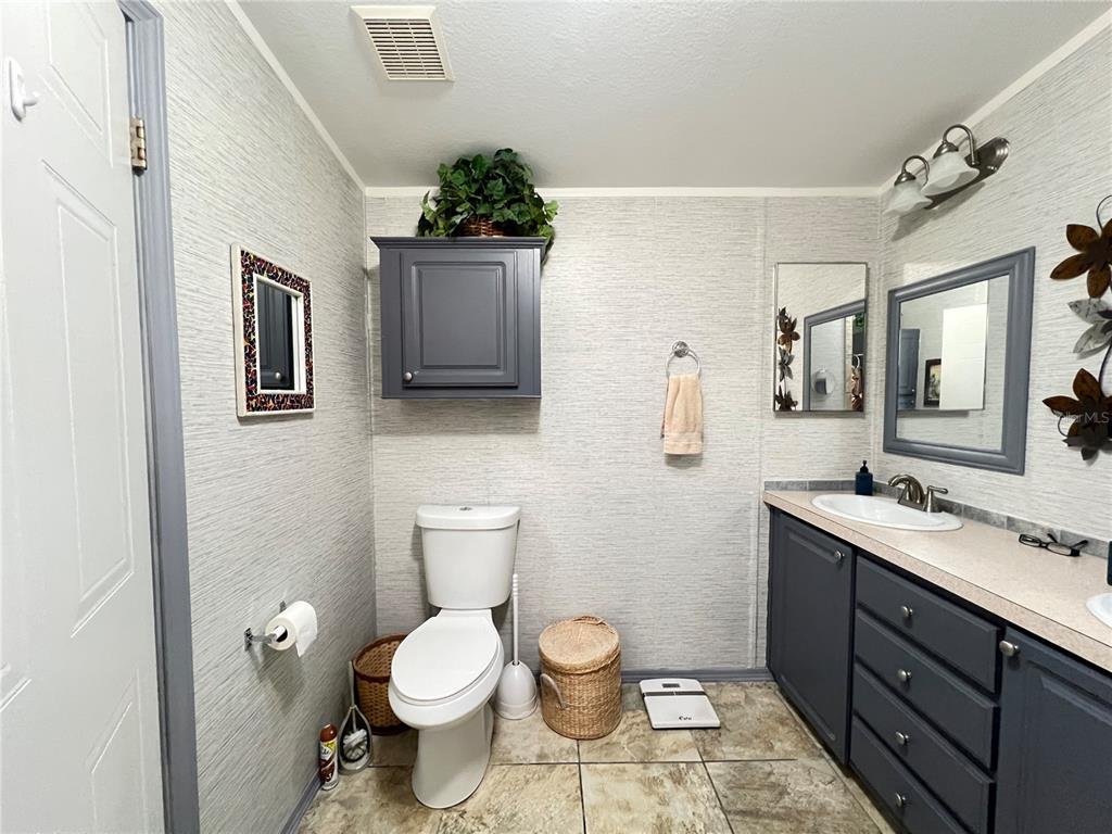 10100 Burnt Store Road, Unit 27 Punta Gorda, FL 33950 - Photo 24 of 37 a bathroom with a toilet sink and mirror