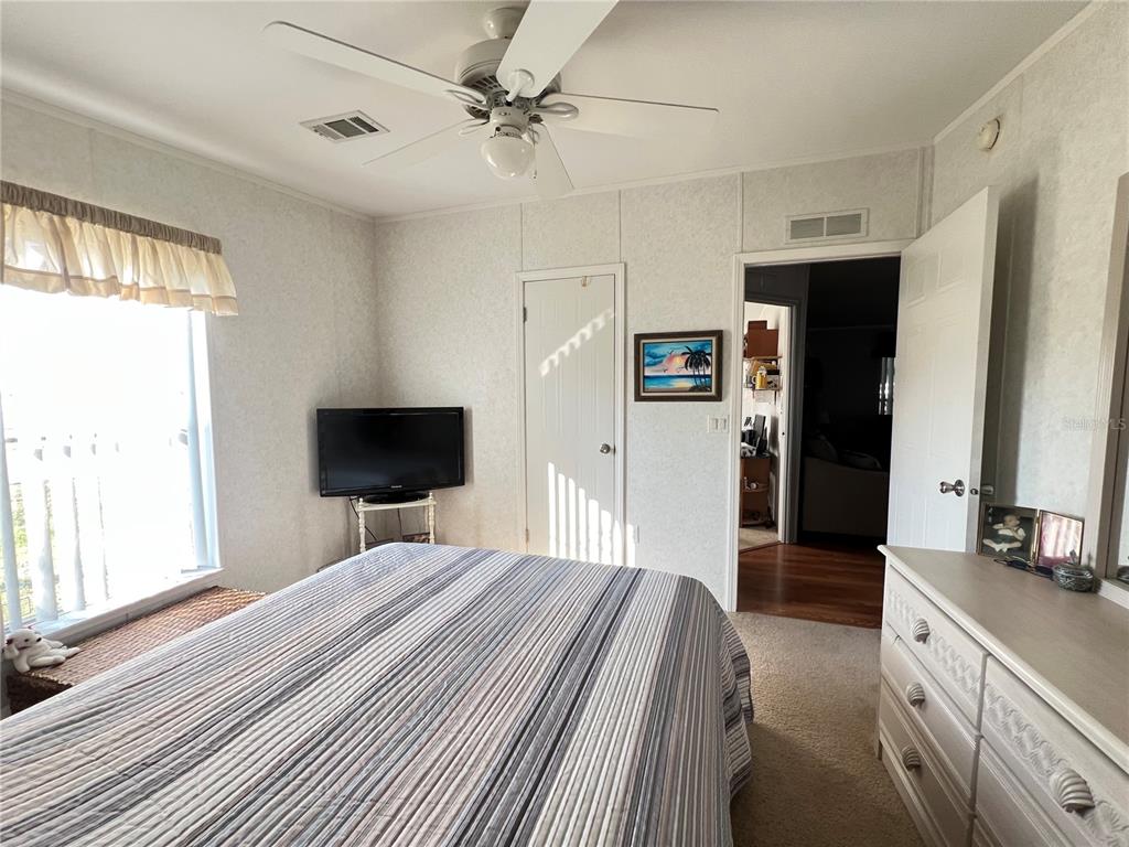 10100 Burnt Store Road, Unit 27 Punta Gorda, FL 33950 - Photo 27 of 37 a bedroom with a bed and a flat screen tv