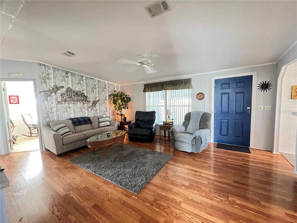 10100 Burnt Store Road, Unit 27 Punta Gorda, FL 33950 - Photo 7 of 37 a living room with furniture and a wooden floor