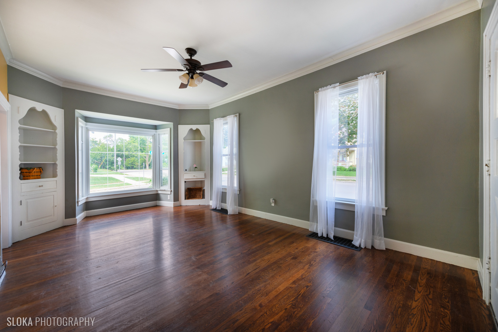 1044 Prospect Street Elgin, IL 60120 - Photo 4 of 21 an empty room with wooden floor chandelier and windows