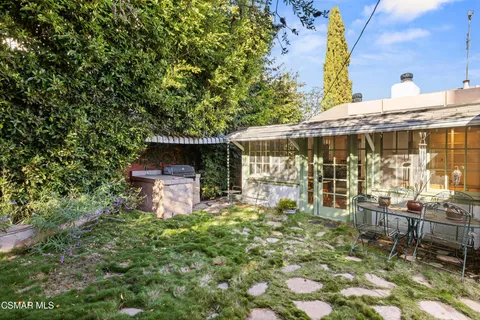 a backyard of a house with table and chairs