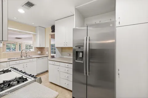 a kitchen with a sink stainless steel appliances and shower