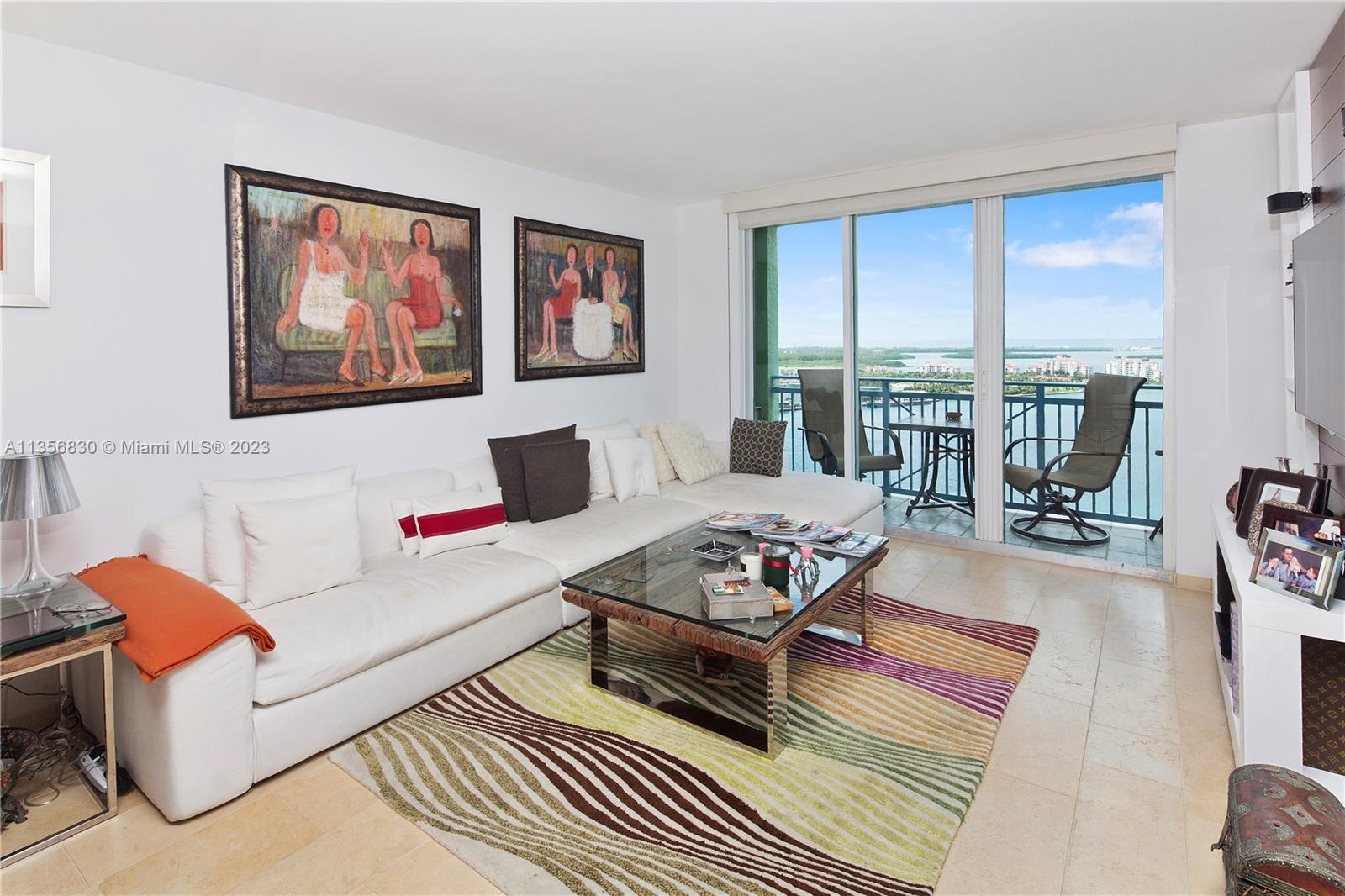 90 Alton Road, Unit 2906 Miami Beach, FL 33139 - Photo 1 of 6 a living room with furniture a rug dining table and a large window