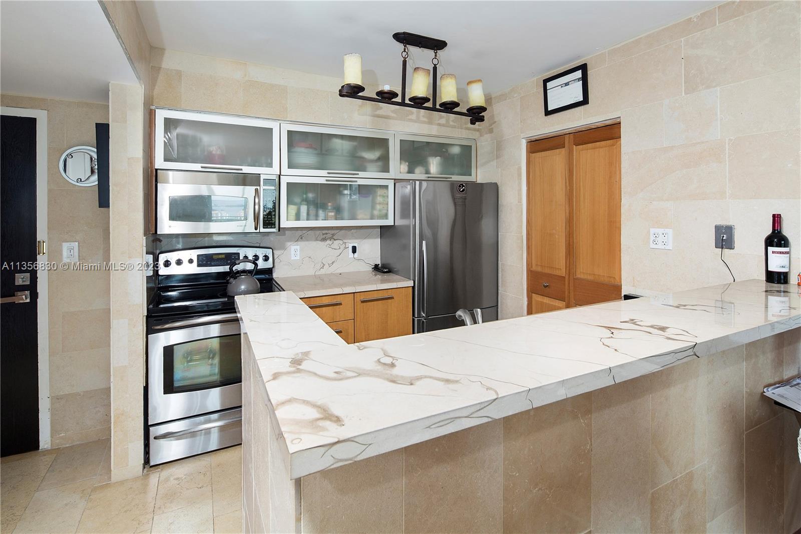 90 Alton Road, Unit 2906 Miami Beach, FL 33139 - Photo 3 of 6 a kitchen view with granite countertop a refrigerator stove and sink