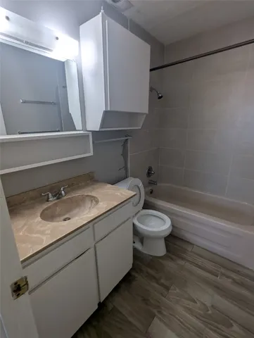 a bathroom with a granite countertop toilet sink and mirror