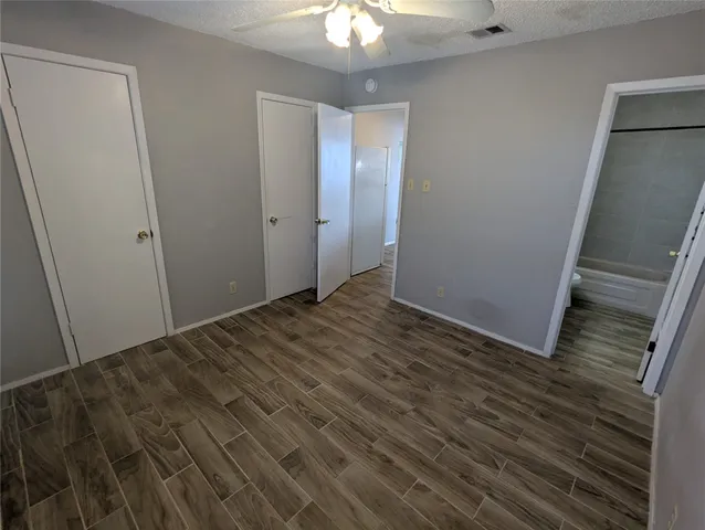 a view of a livingroom with wooden floor and a chandelier fan