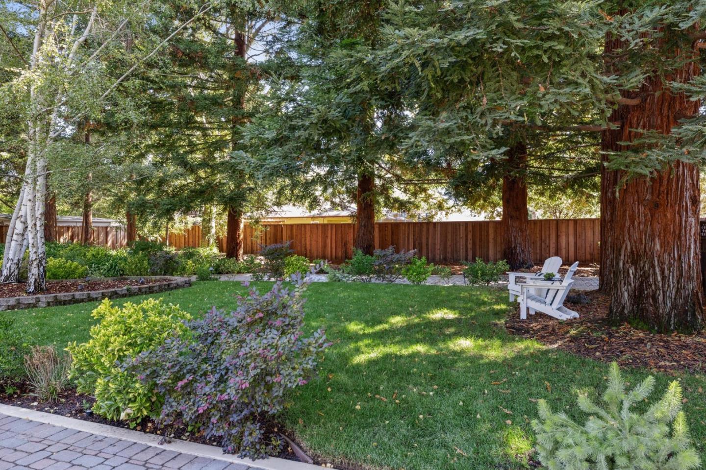 961 Berkeley Avenue Menlo Park, CA 94025 - Photo 4 of 27 a view of a backyard with table and chairs and a large tree