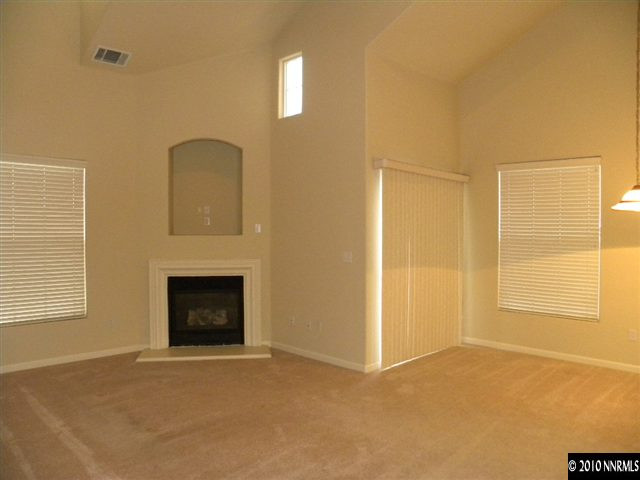9050 Double R Boulevard, Unit 124 Reno, NV 89521 - Photo 5 of 9 a view of an empty room with a fireplace and a window