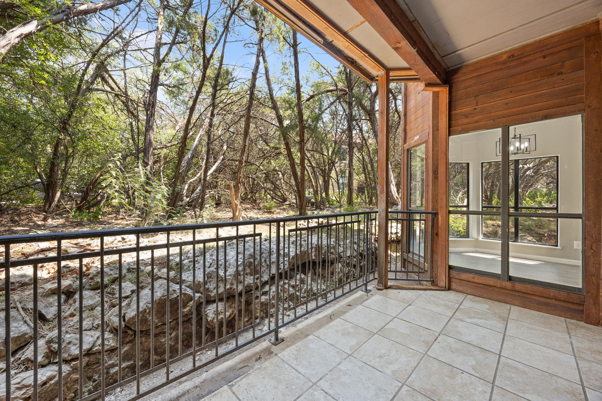 4711 Spicewood Springs Road, Unit 1106 Austin, TX 78759 - Photo 15 of 19 Outdoor patio featuring tiled flooring, a black metal railing, and wood-paneled walls