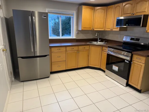 a kitchen with stainless steel appliances granite countertop a refrigerator sink and stove