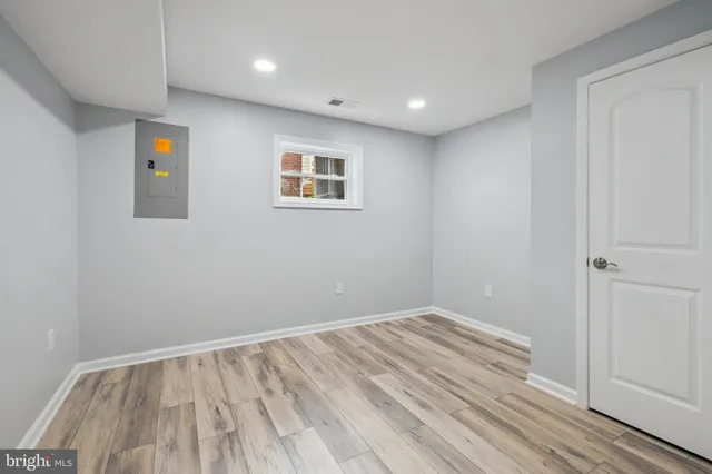 a view of empty room with wooden floor