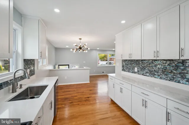 a large kitchen with kitchen island white cabinets and stainless steel appliances