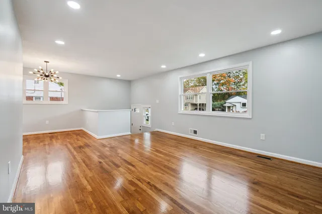 a view of empty room with wooden floor