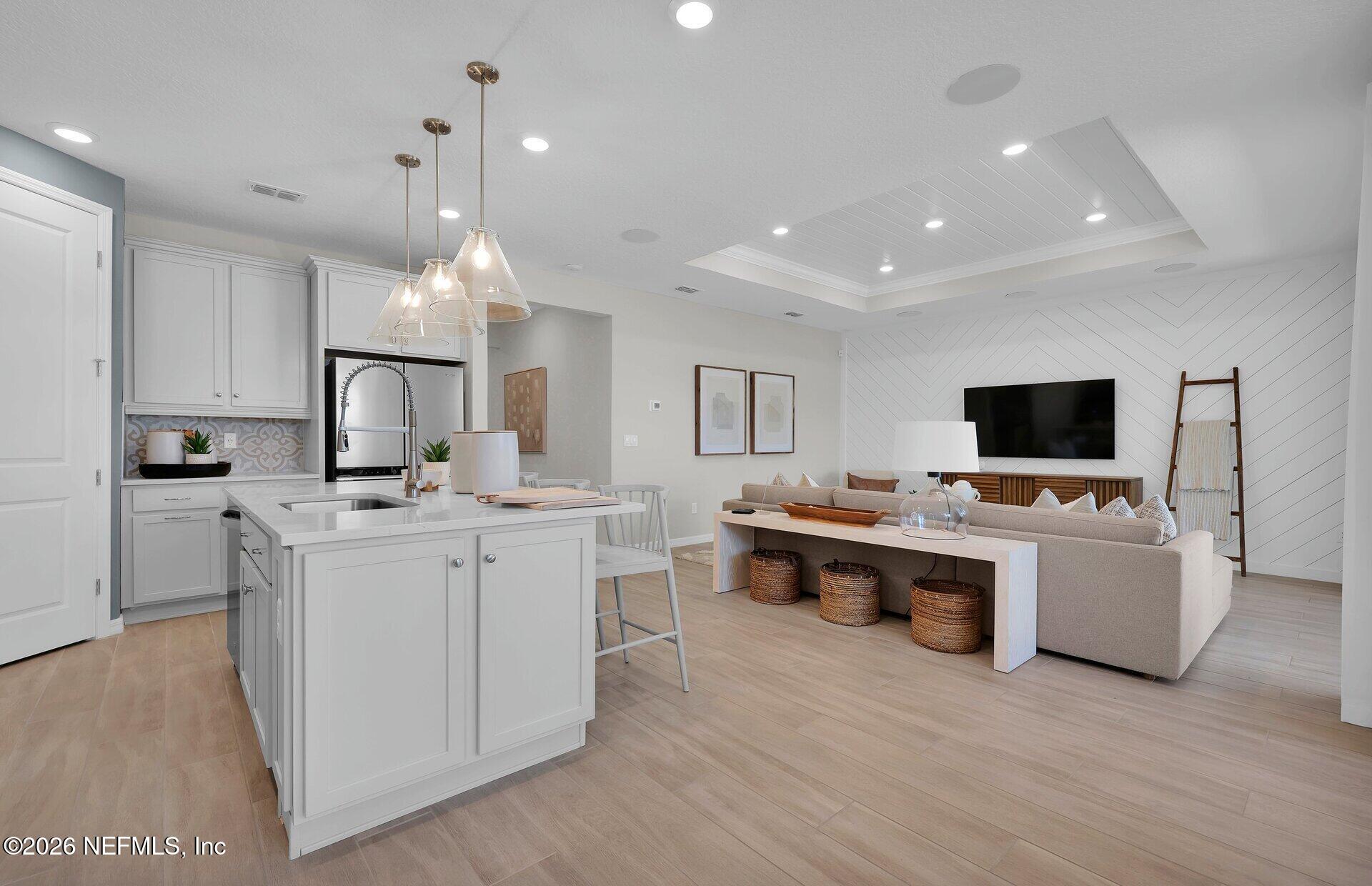 908 Rooster Hollow Way Middleburg, FL 32068 - Photo 6 of 26 a large white kitchen with a large counter top and stainless steel appliances