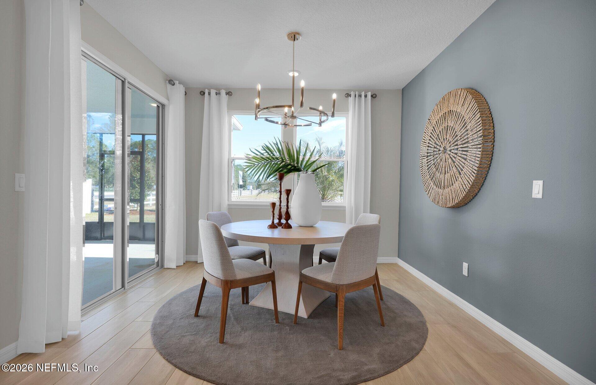 908 Rooster Hollow Way Middleburg, FL 32068 - Photo 8 of 26 a dining room with furniture a potted plant and a rug