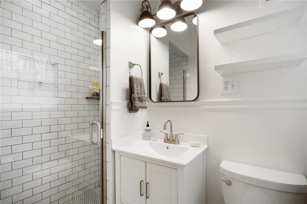 961 East Rock Springs Road Northeast, Unit MODERN Atlanta, GA 30306 - Photo 26 of 47 a bathroom with a toilet a sink a mirror and vanity