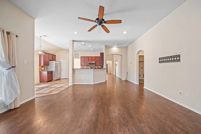 a view of a kitchen with a sink refrigerator and wooden floor