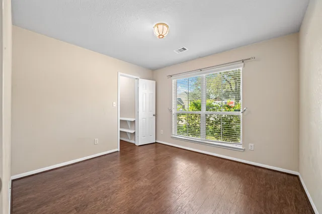 an empty room with wooden floor and a window
