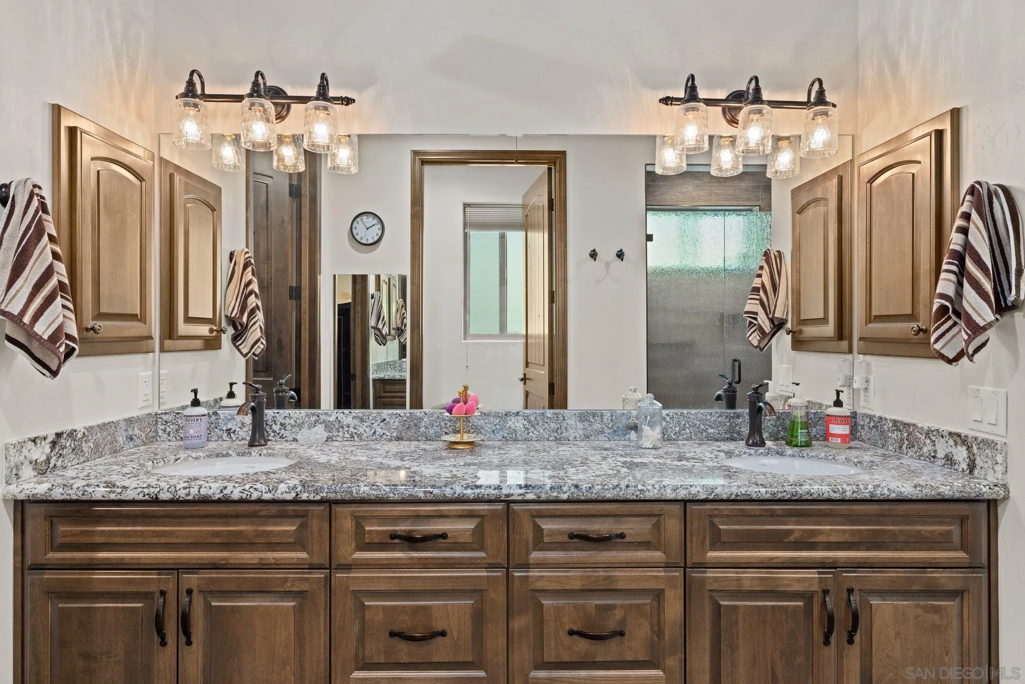 19553 Hidden Glen Road Alpine, CA 91901 - Photo 24 of 55 a bathroom with a granite countertop sink a large mirror and a vanity