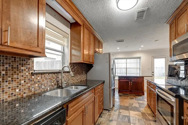 a kitchen with stainless steel appliances granite countertop a sink stove and cabinets