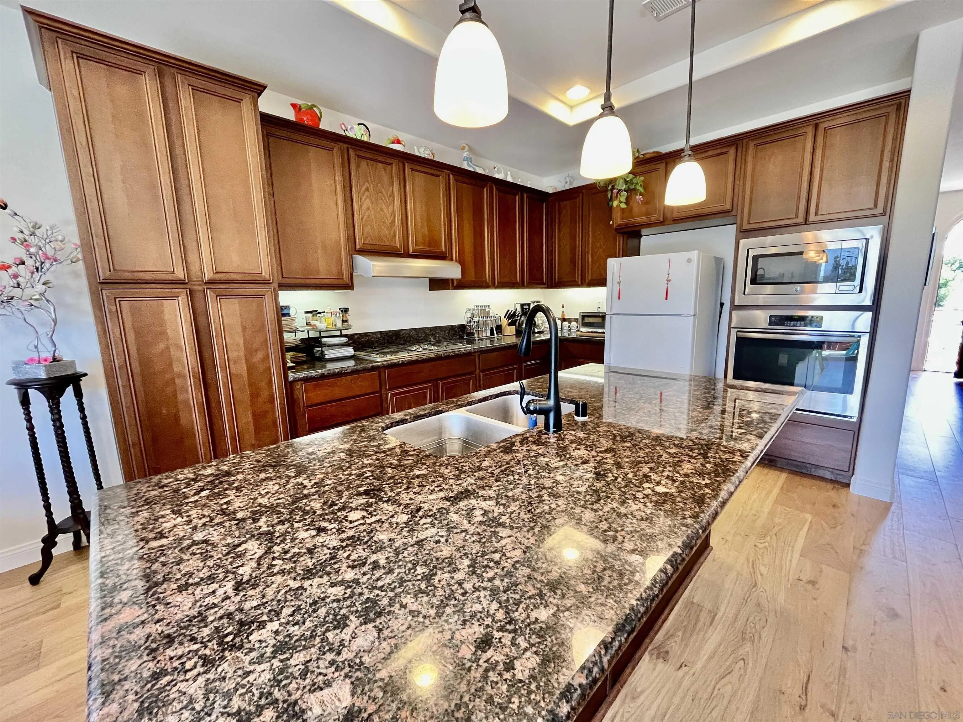 888 Rancho Terrace Ct. El Cajon, CA 92019 - Photo 15 of 34 a kitchen with stainless steel appliances kitchen island granite countertop a refrigerator stove top oven and cabinets