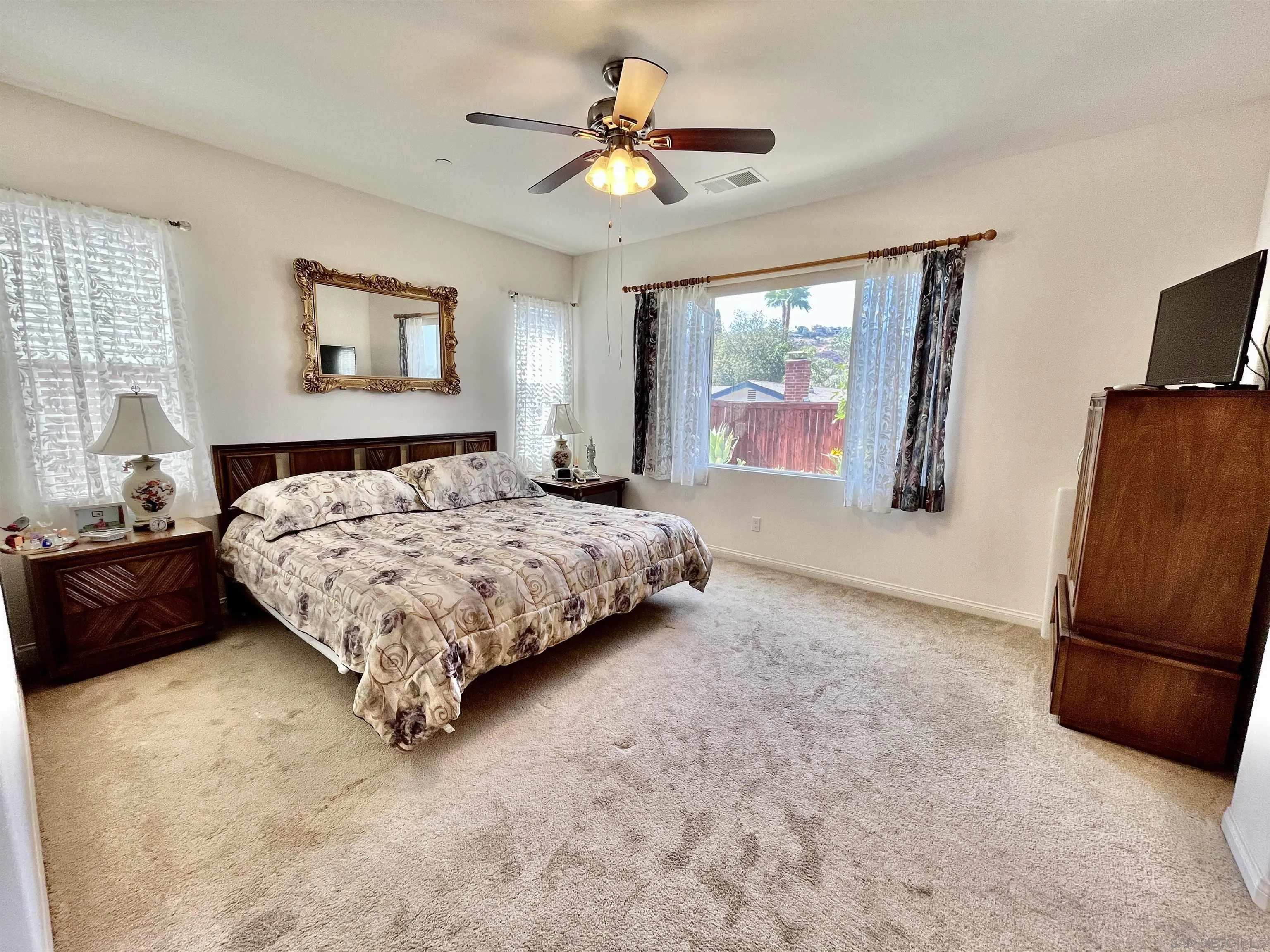 888 Rancho Terrace Ct. El Cajon, CA 92019 - Photo 24 of 34 a bedroom with a bed a couch and a chandelier