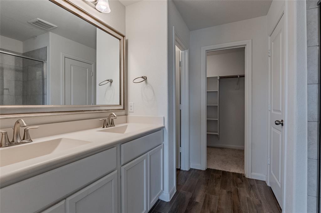 240 Copper Switch Drive Anna, TX 75409 - Photo 13 of 33 Full bath with wood finished floors, a stall shower, double vanity, and a walk in closet