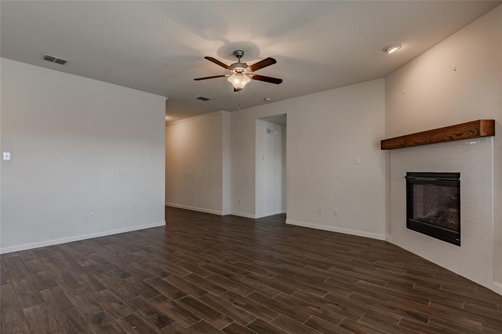 240 Copper Switch Drive Anna, TX 75409 - Photo 18 of 33 Unfurnished living room featuring a ceiling fan, dark wood-style floors, and a brick fireplace