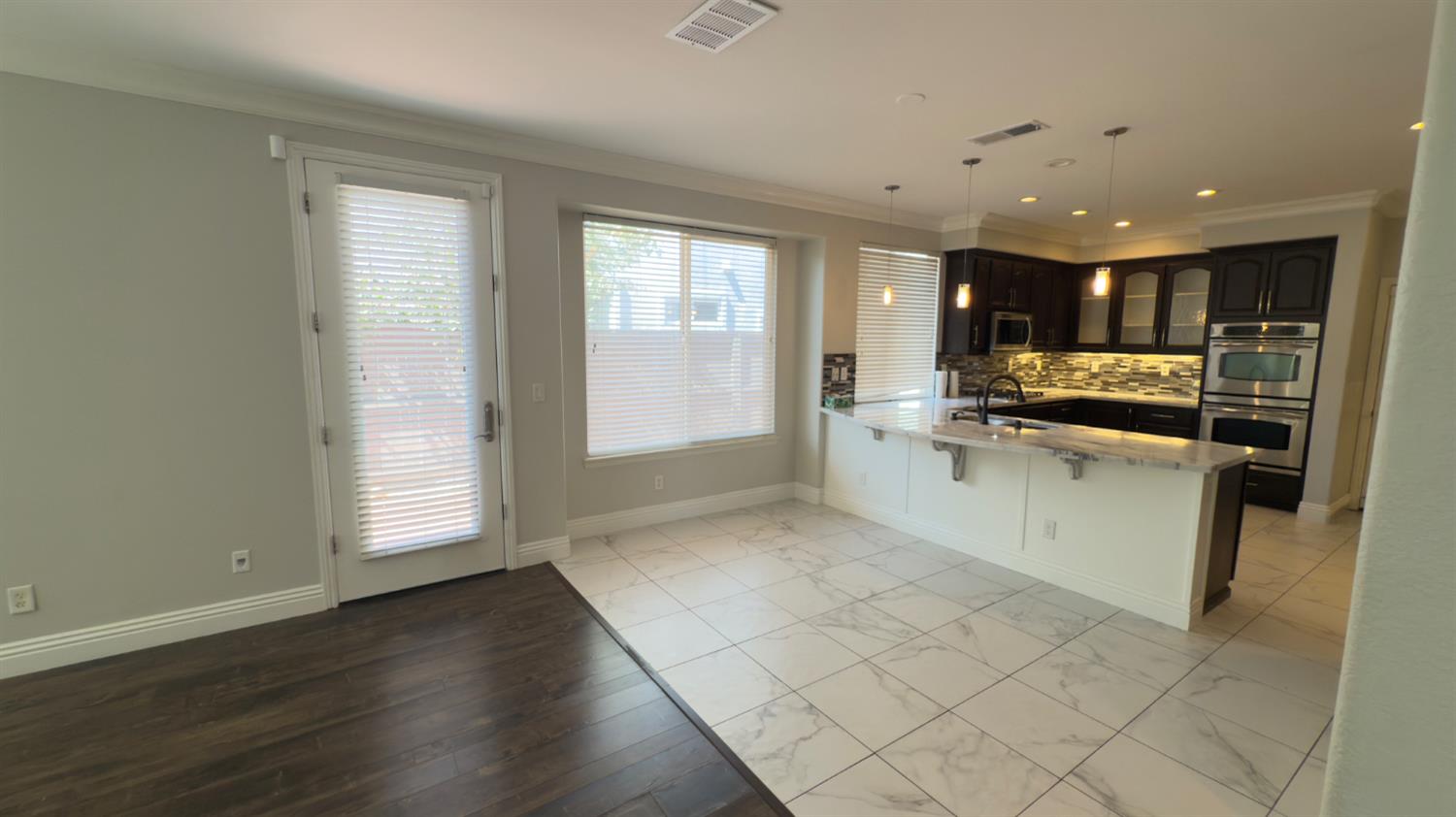 11816 Spring Walk Way Rancho Cordova, CA 95742 - Photo 11 of 36 a large kitchen with cabinets and a wooden floor