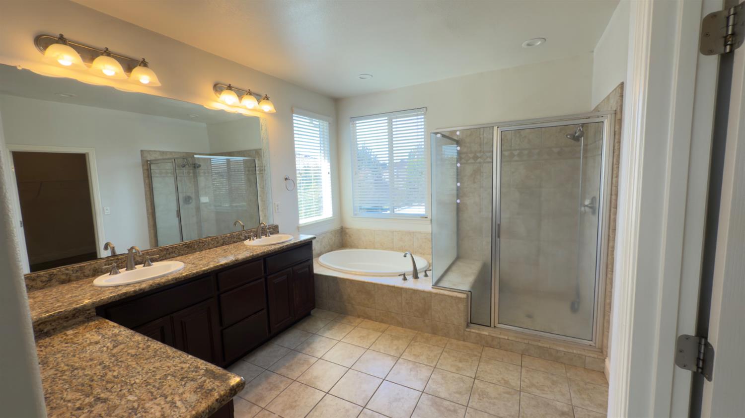 11816 Spring Walk Way Rancho Cordova, CA 95742 - Photo 27 of 36 a spacious bathroom with a bathtub sink and mirror