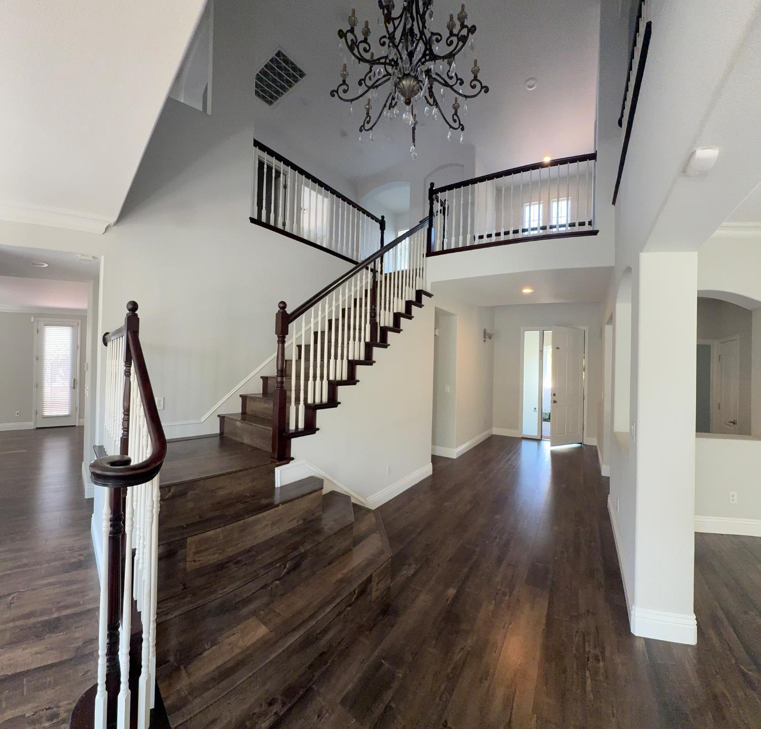 11816 Spring Walk Way Rancho Cordova, CA 95742 - Photo 5 of 36 a view of staircase with wooden floor and a chandelier