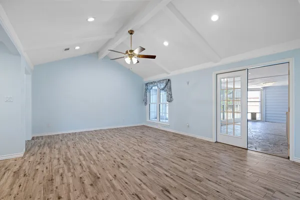 a view of an empty room with a kitchen and window