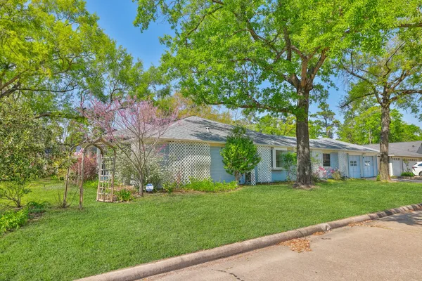 a front view of a house with a garden and a tree