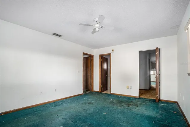an empty room with closet and a chandelier fan