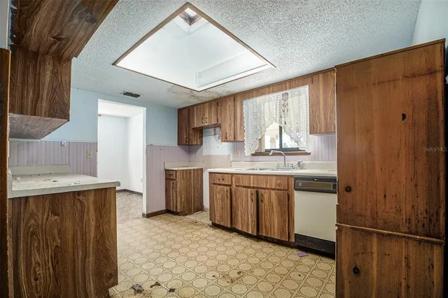 a kitchen with granite countertop a sink stainless steel appliances and cabinets