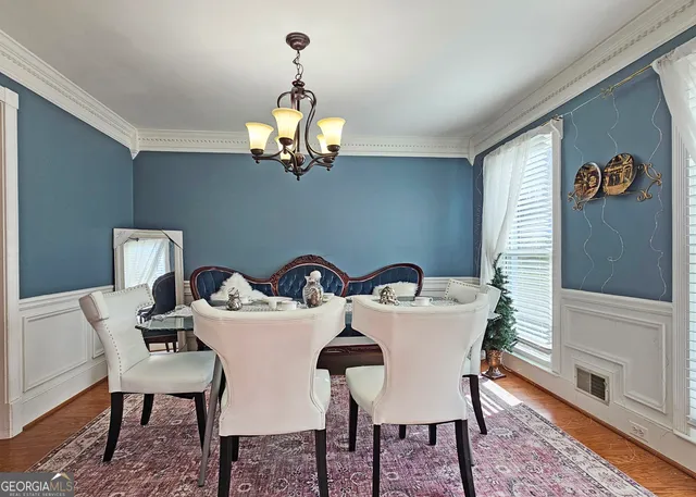 a view of a dining room with furniture wooden floor and a chandelier