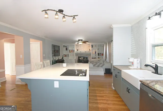 a large kitchen with sink a refrigerator and a view of living room