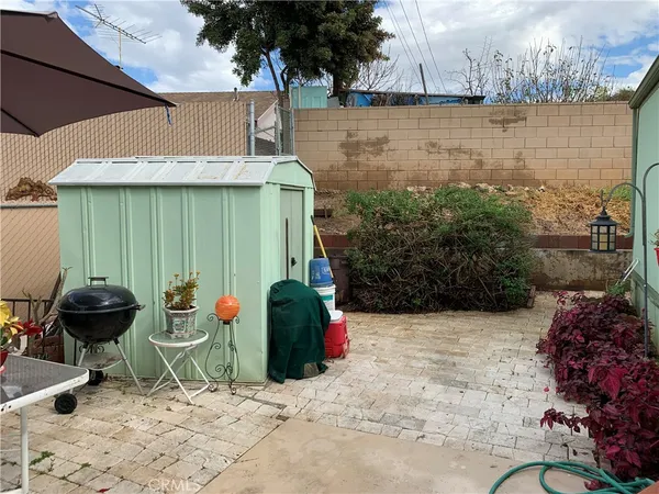 a view of a garden with chair and potted plants