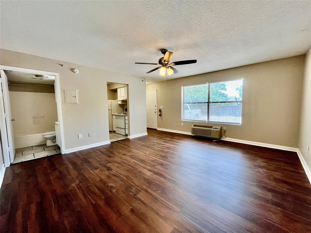 a view of a livingroom with wooden floor and a ceiling fan