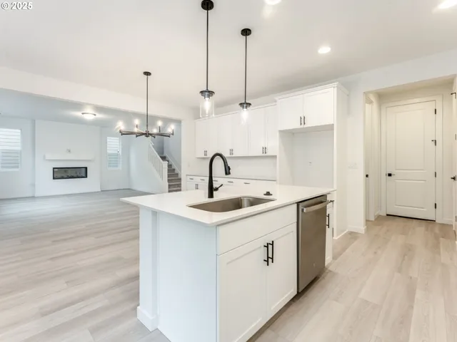 a kitchen with a sink stove and wooden floor
