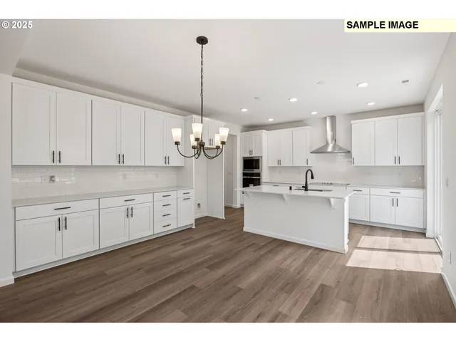 a large kitchen with stainless steel appliances kitchen island a refrigerator a sink dishwasher a stove and white cabinets next to a window